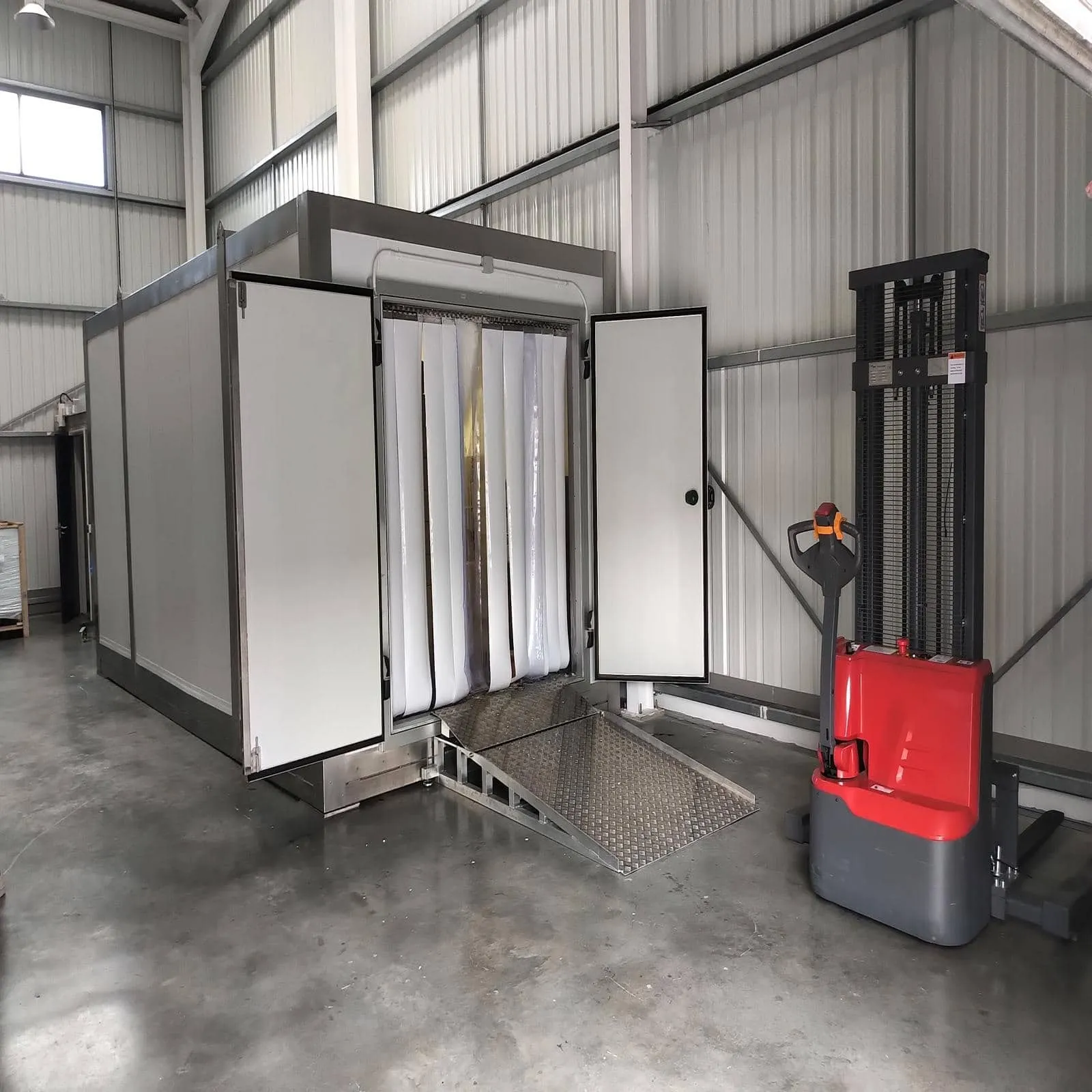 Walk-in freezer pod with strip curtain and loading ramp